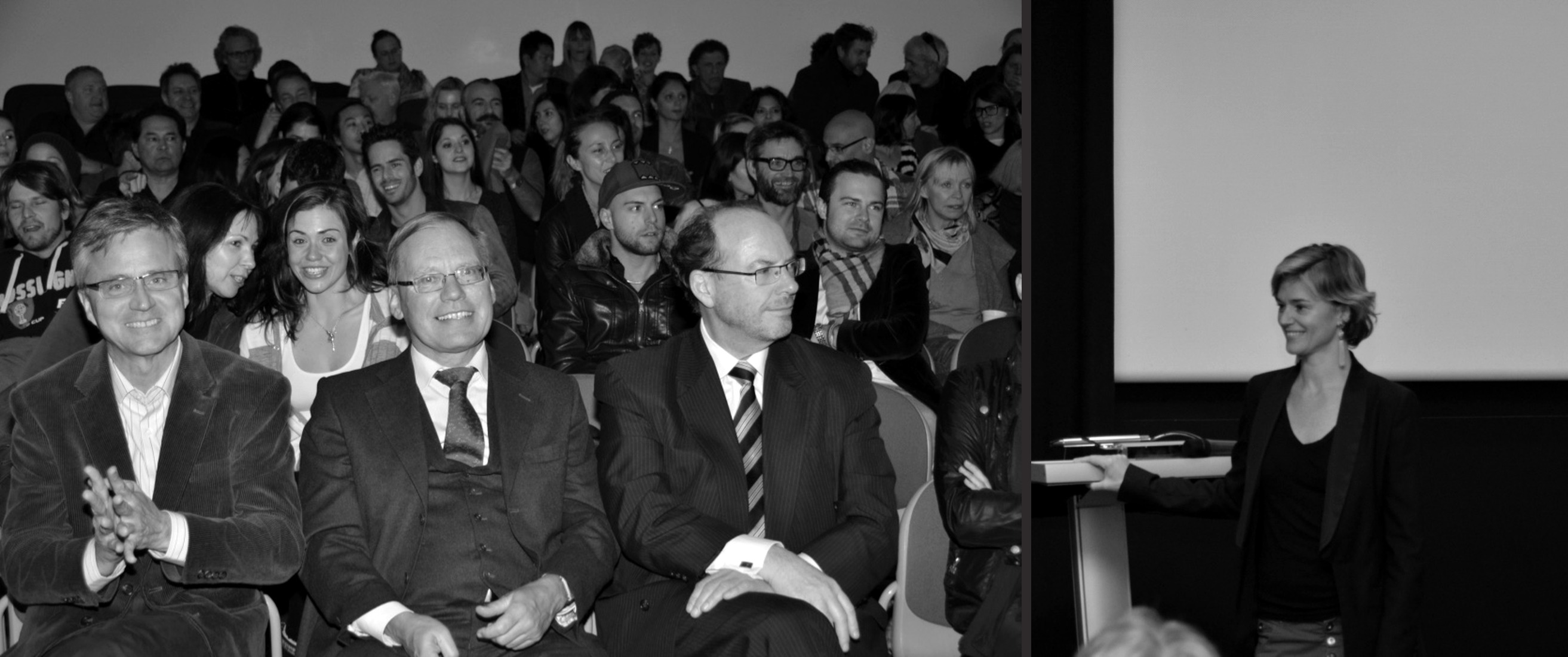An audience watching intently, and Jo standing before a screen addressing a room